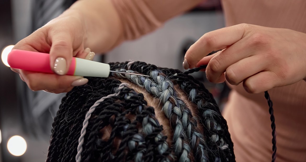 Cabeleireira fazendo trança twist em um cabelo.